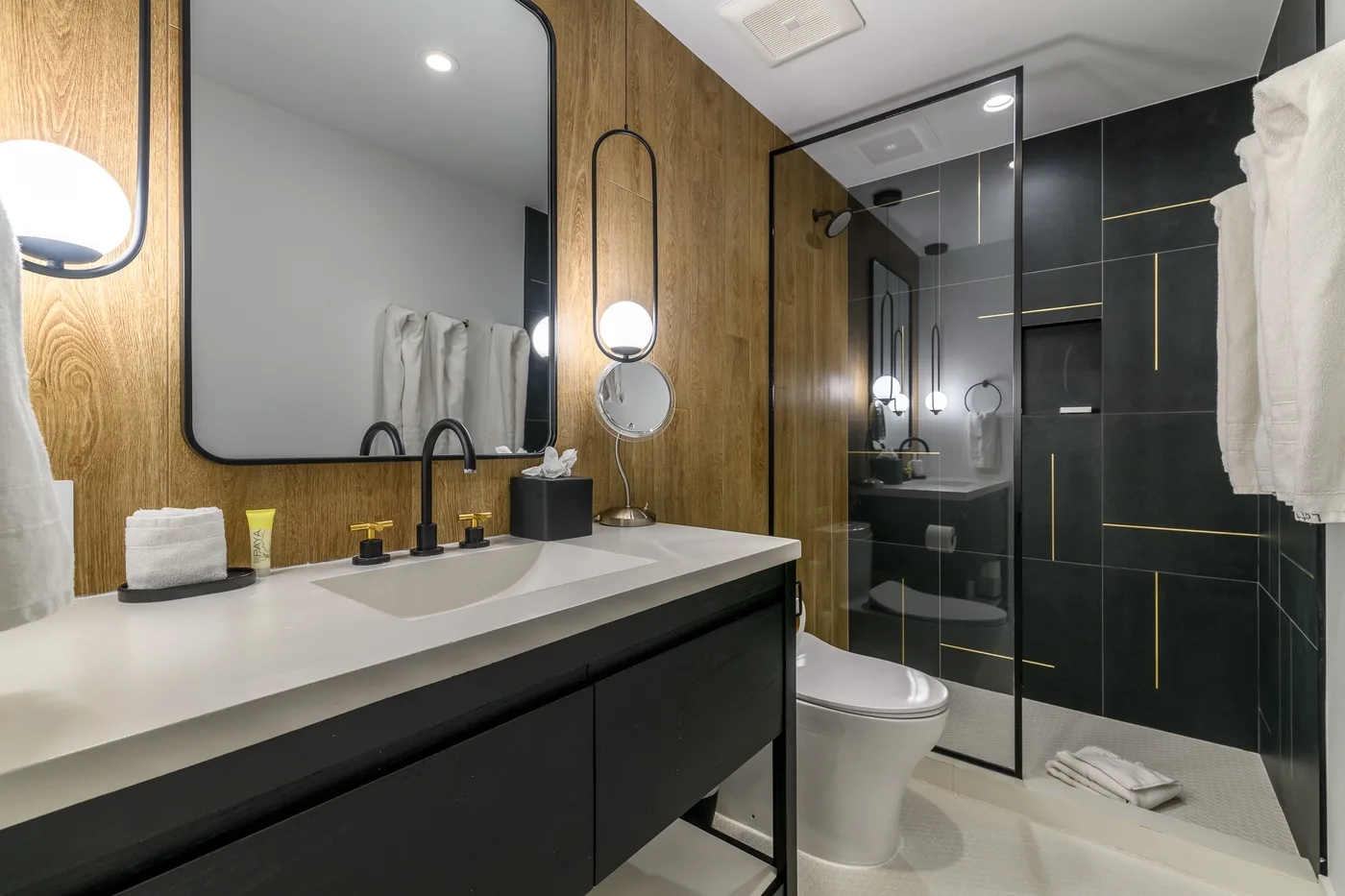Un baño moderno tiene un tocador largo junto a una ducha de vidrio.