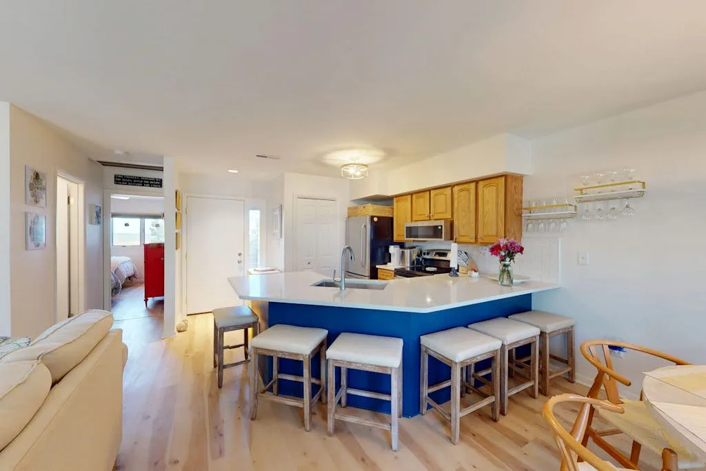 An open kitchen and dining area features a blue island with seating.