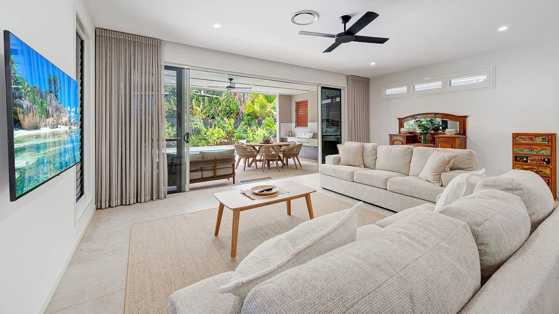 A bright living room with light-colored seating and a coffee table.