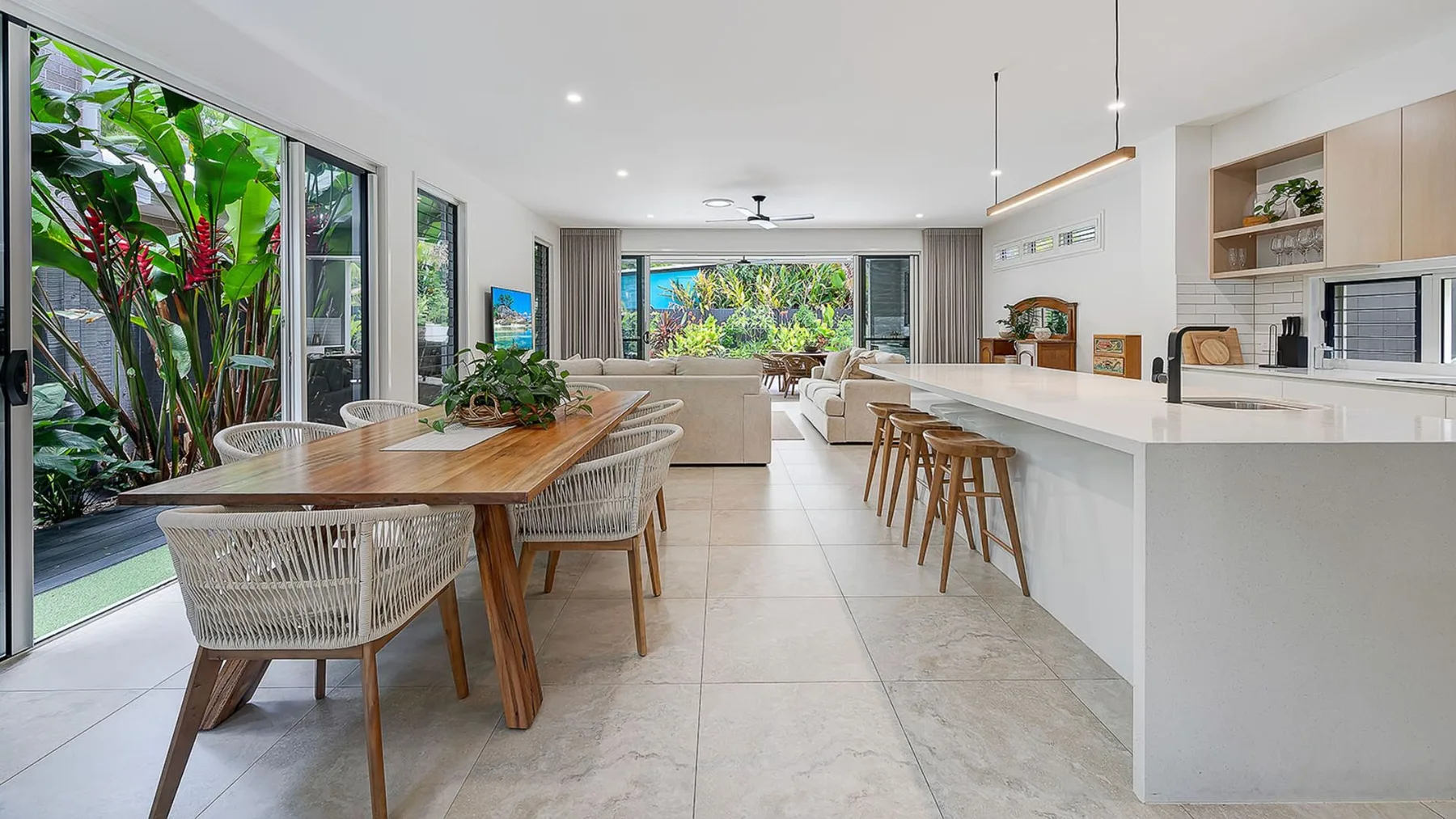 Open-plan kitchen and dining area with a long island and large windows.