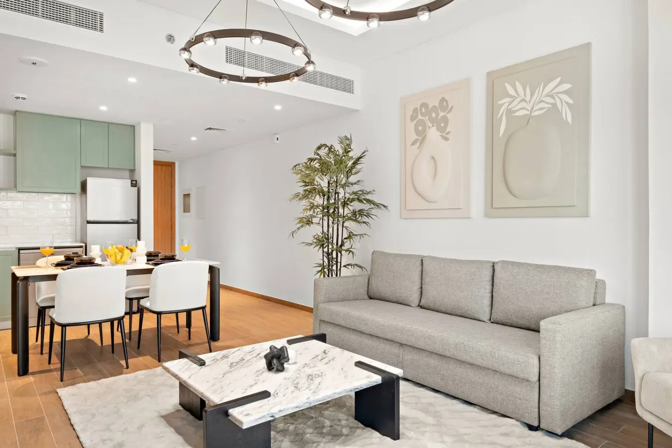 Una luminosa sala de estar y comedor con un sofá gris y una mesa de comedor.