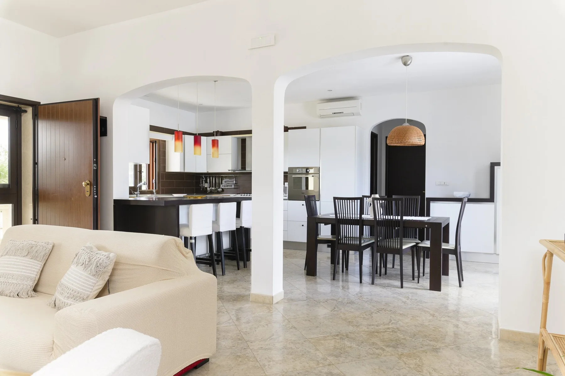Una zona diáfana de sala, comedor y cocina con mesa de comedor y asientos.