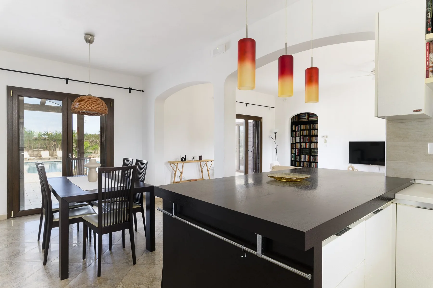 Cocina y comedor de planta abierta con una isla grande y una mesa de comedor.