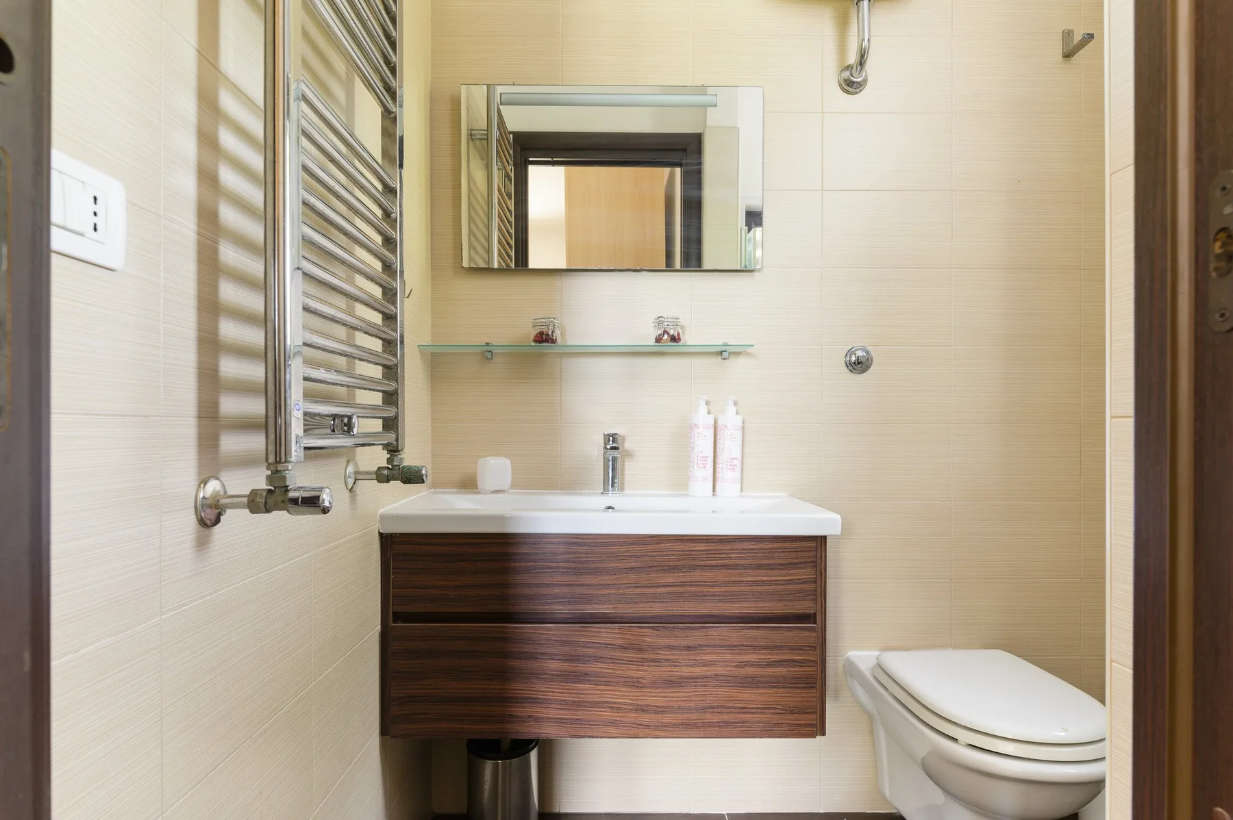 Un baño con lavabo, espejo e inodoro.