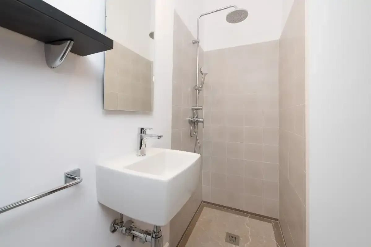 Un baño con lavabo suspendido y ducha.
