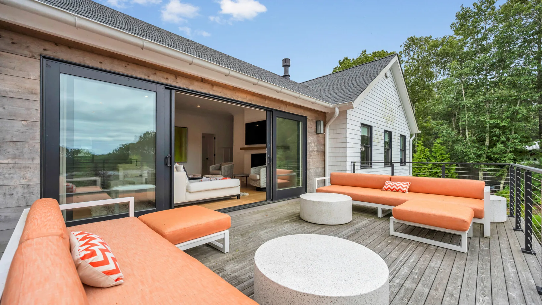 Una terraza de madera con asientos al aire libre junto a una casa moderna.