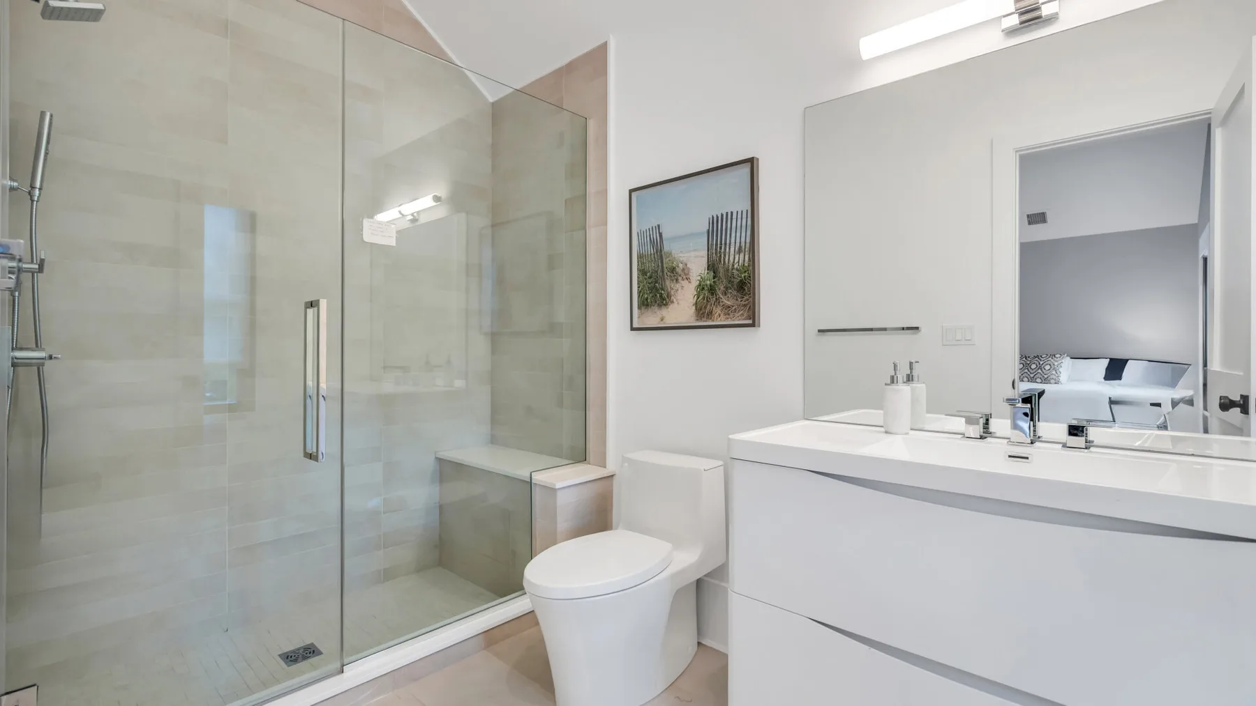 Un baño luminoso con ducha de vidrio, inodoro y un amplio tocador.