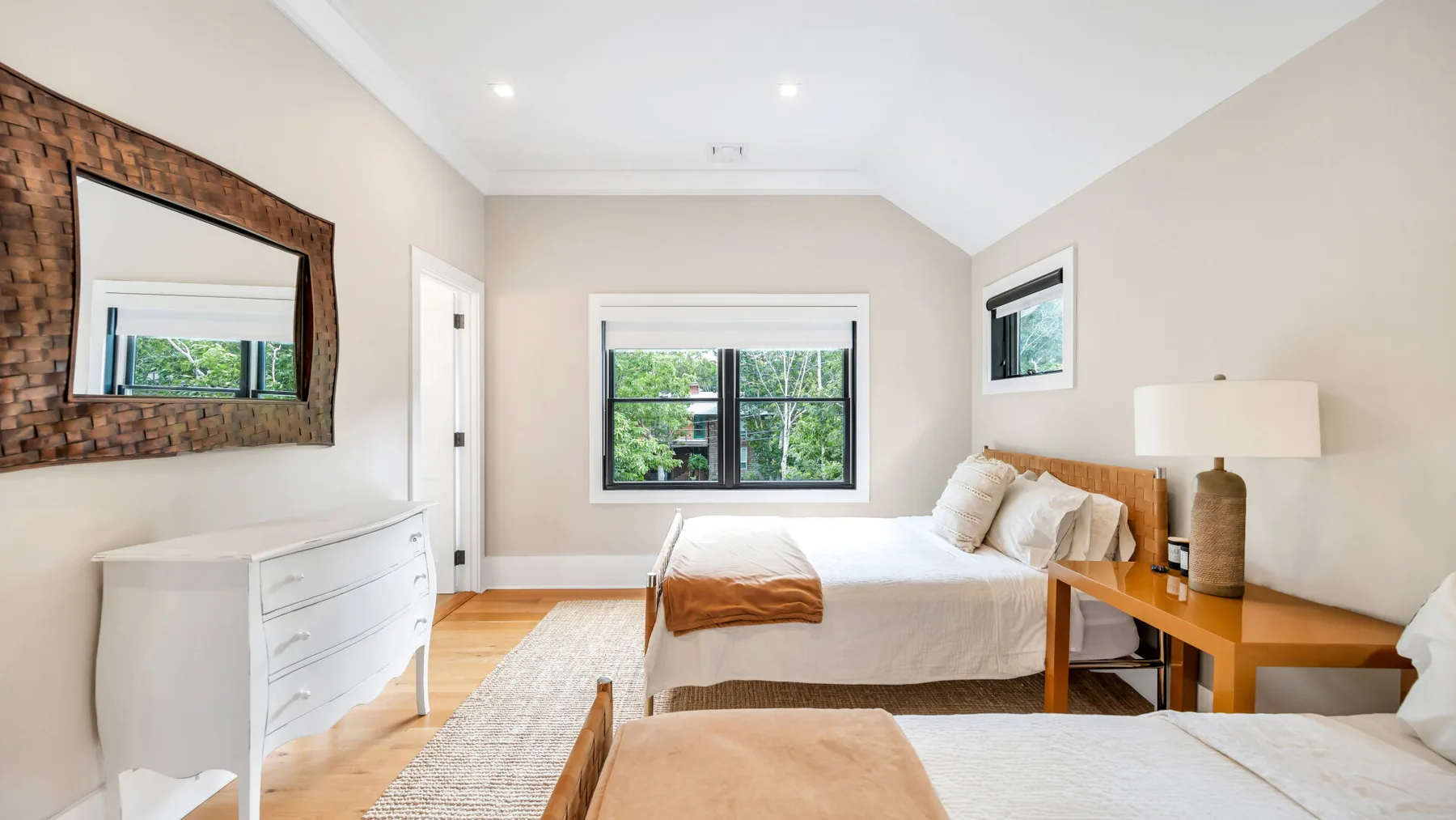 Un dormitorio con una cama, una mesita de noche y una cómoda.