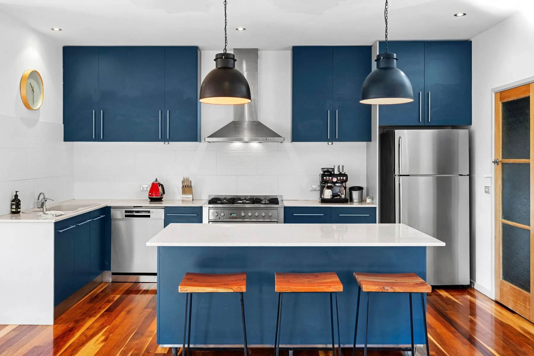 A modern kitchen with blue cabinets and a central island.