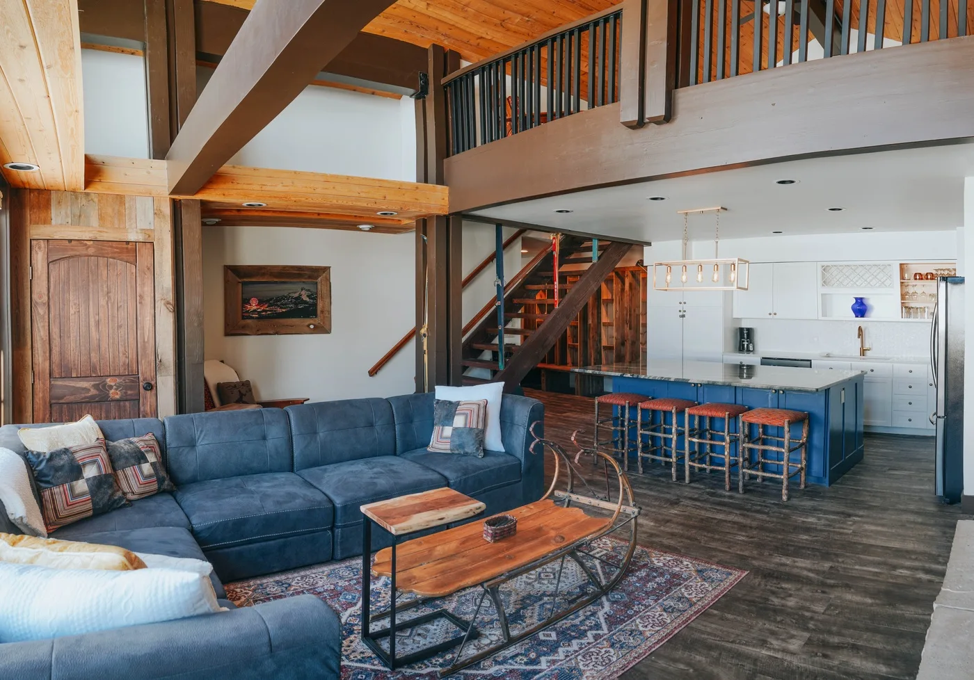 A double-height living room opens onto a kitchen, with a staircase between them.