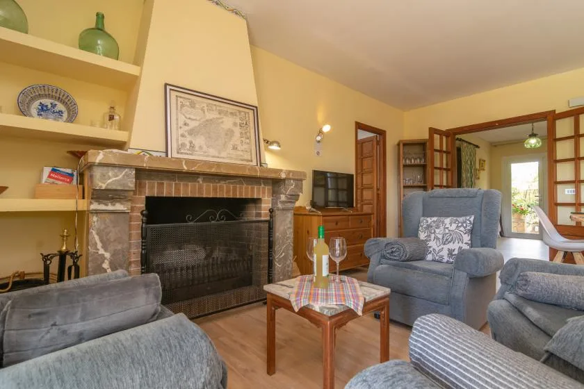 A living room with seating around a fireplace and a small table.