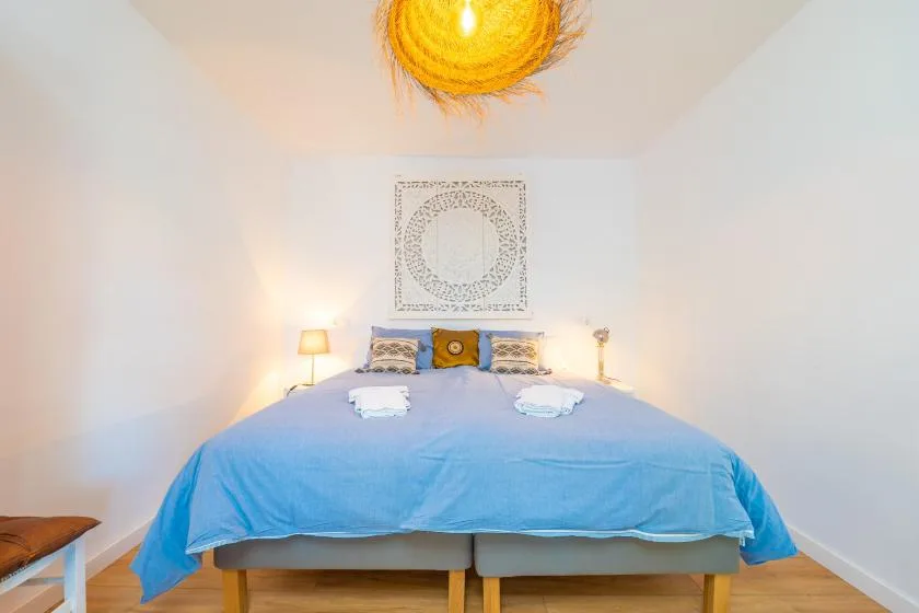 Bedroom with a blue-covered bed and matching bedside lamps.