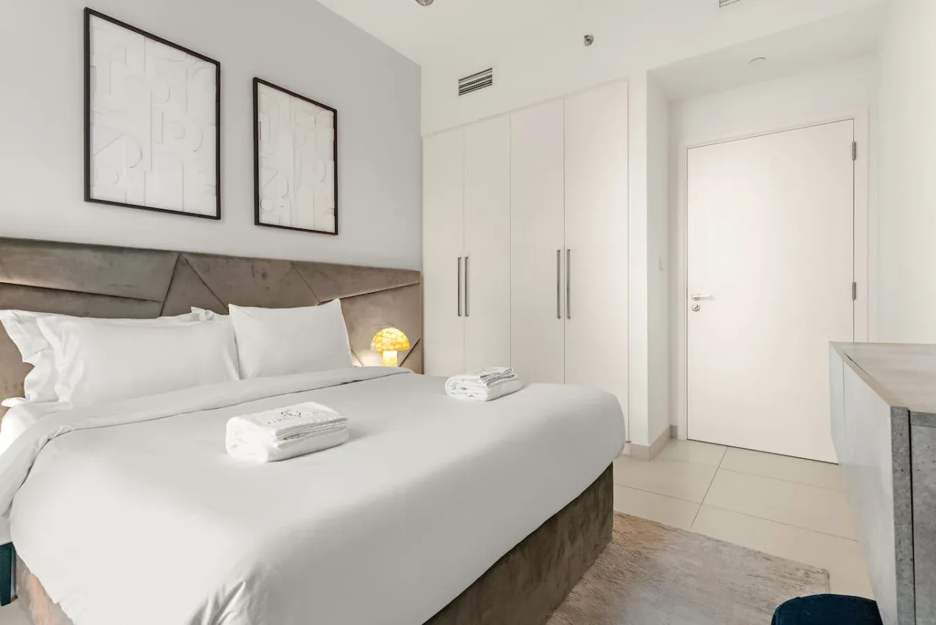 Un dormitorio con una cama bien tendida y armarios empotrados.