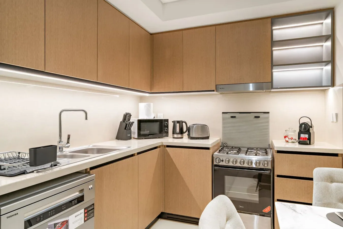 Una cocina moderna con gabinetes de madera, una encimera y electrodomésticos.