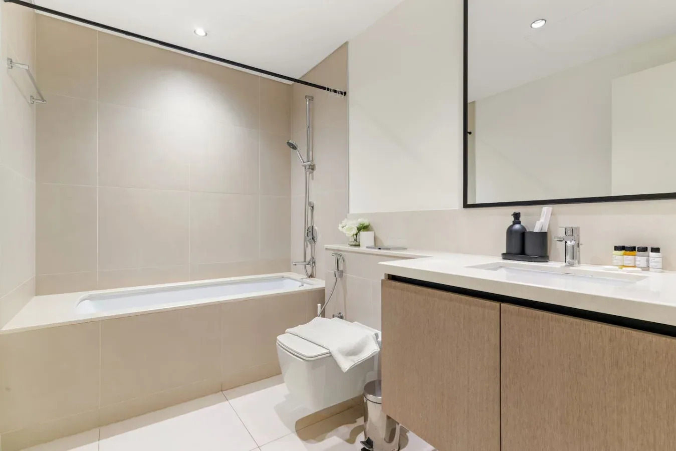 Un baño luminoso con bañera, ducha y tocador.