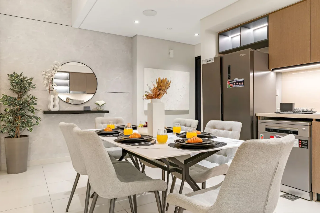 Un comedor con mesa y sillas junto a una cocina abierta.