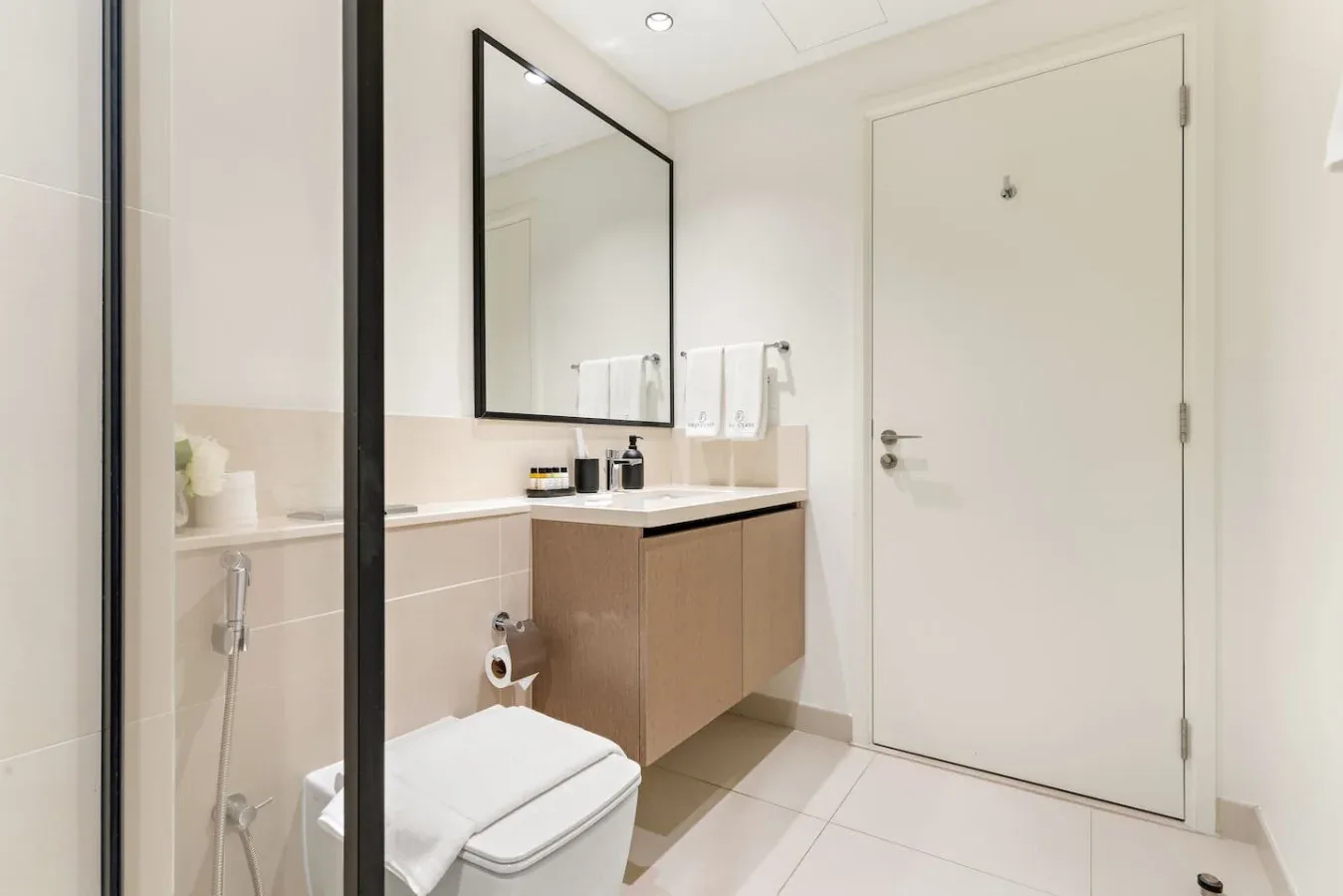 Un baño luminoso con lavabo, espejo e inodoro.