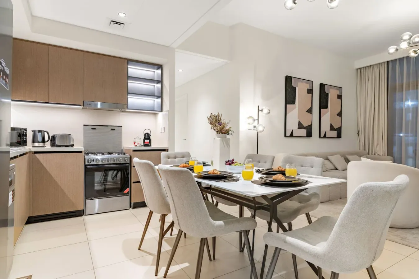 Una cocina abierta al comedor, con la mesa preparada para comer.