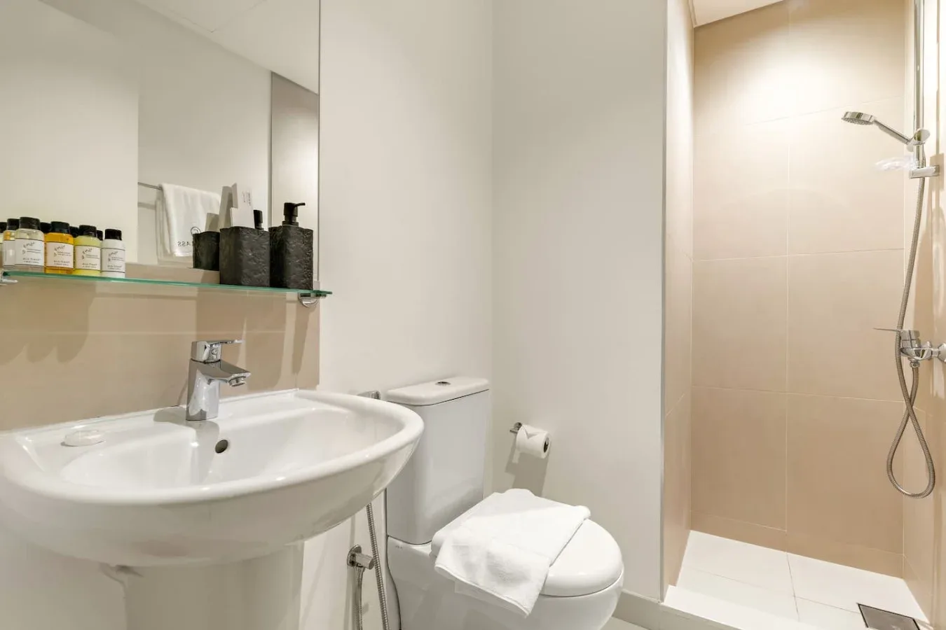 Un baño luminoso con lavabo, inodoro y ducha.