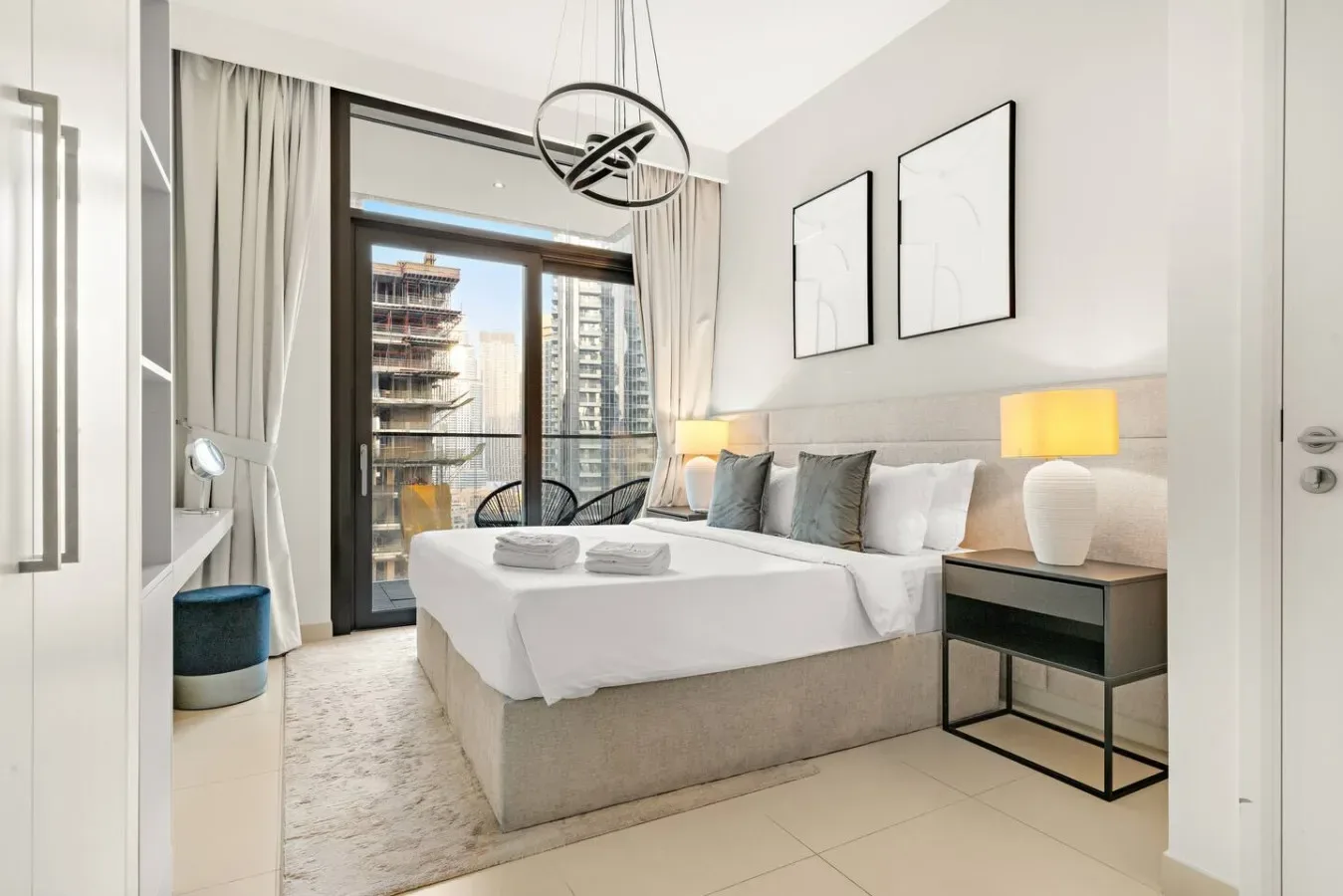Un dormitorio luminoso con una cama bien arreglada y ventanales grandes.