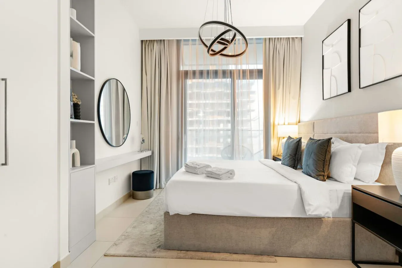 Un dormitorio luminoso con una cama grande, mesillas y cortinas que enmarcan una ventana.