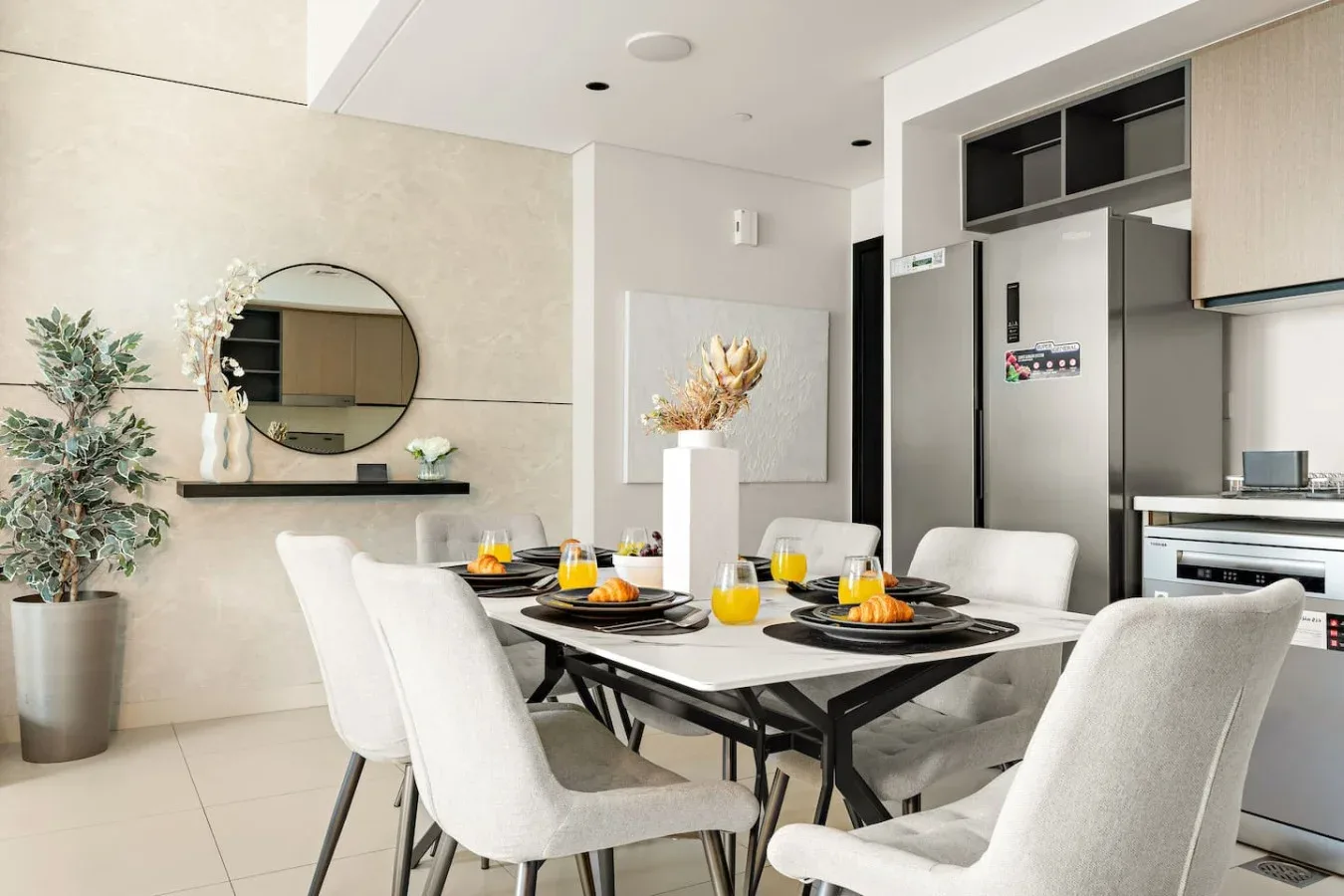 Un comedor luminoso con una mesa puesta junto a una cocina moderna.
