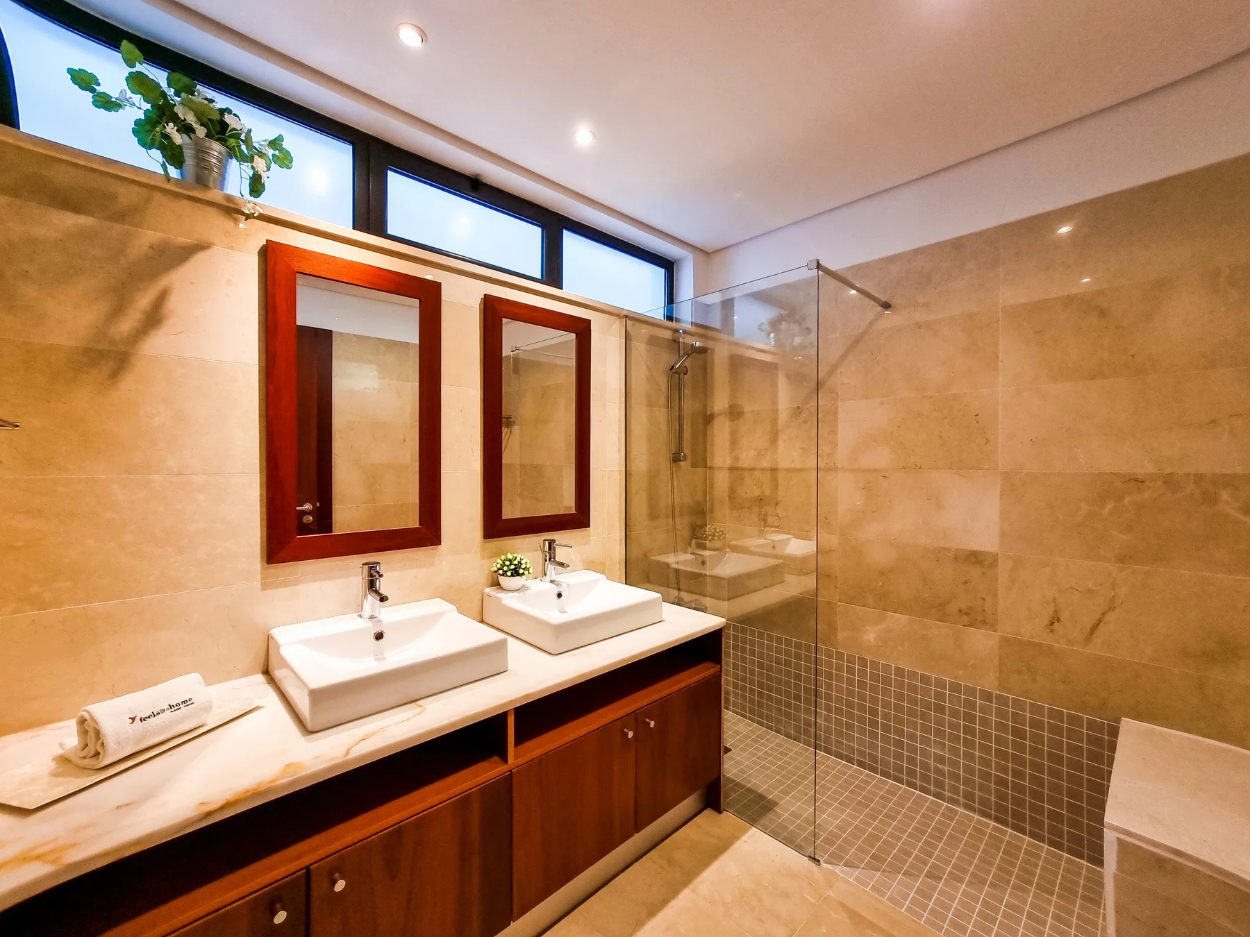Un baño con dos lavabos y una ducha de vidrio.