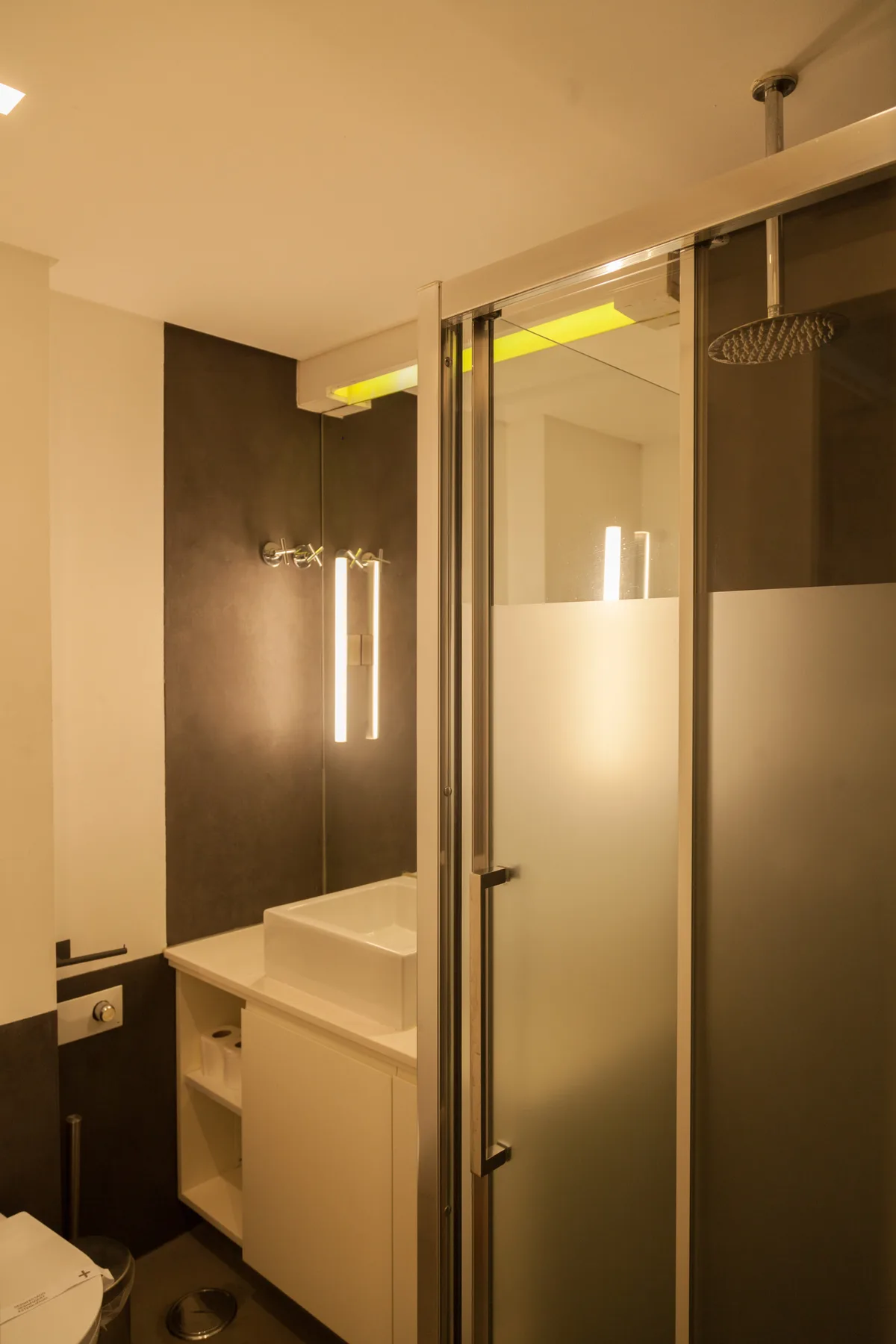 A bathroom with a sink, mirror, and glass shower.