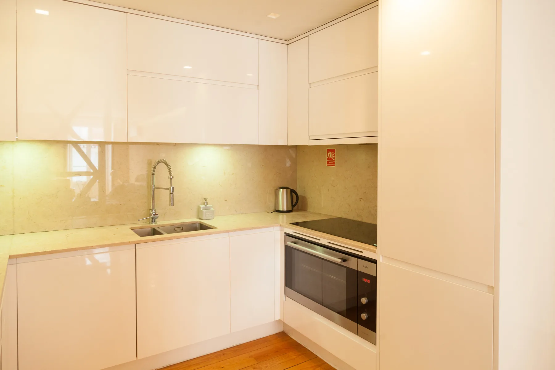 A bright modern kitchen with white cabinets and a built-in oven.