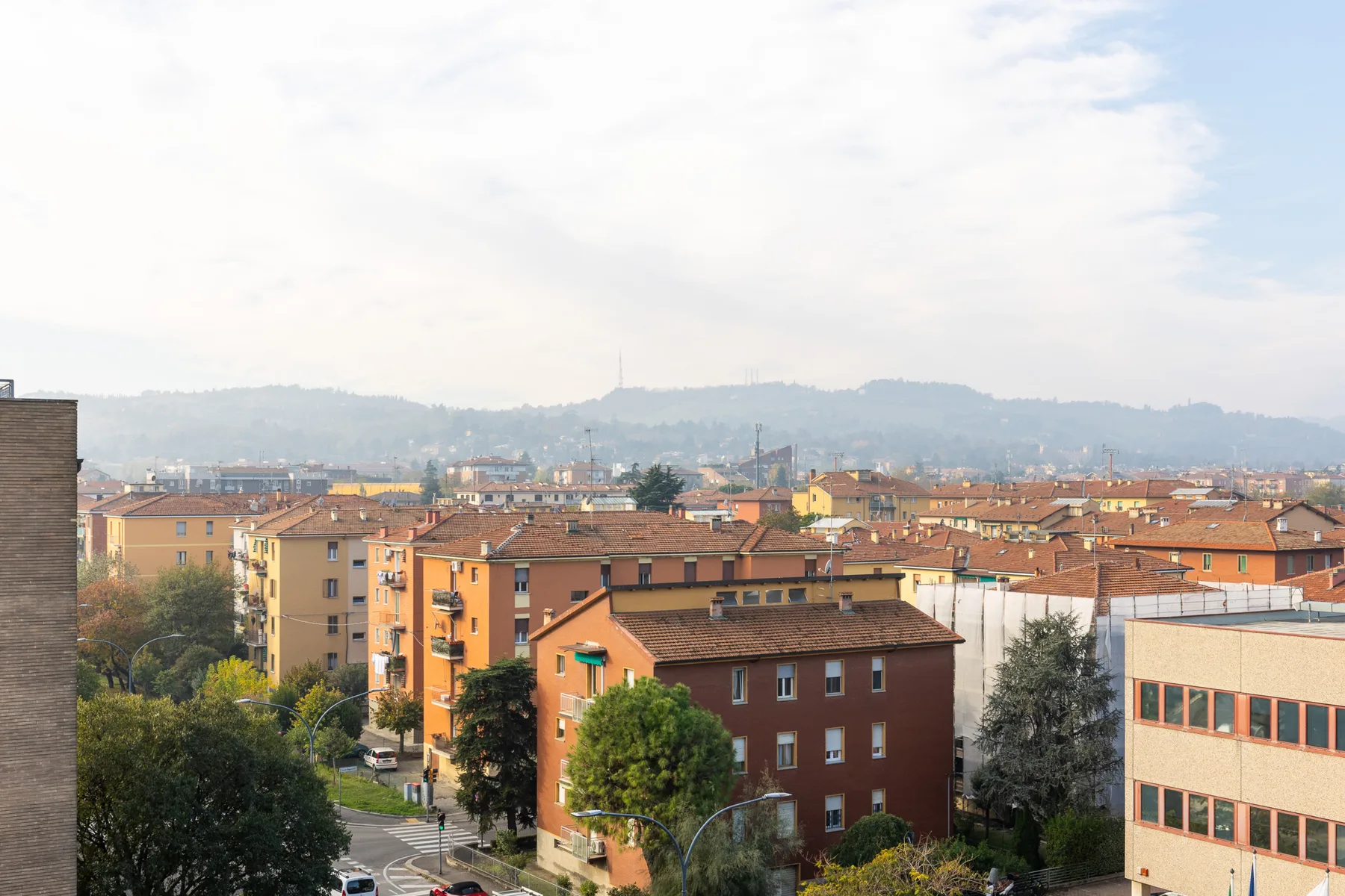 Un paisaje urbano de edificios bajos y tejados bajo un cielo brumoso.