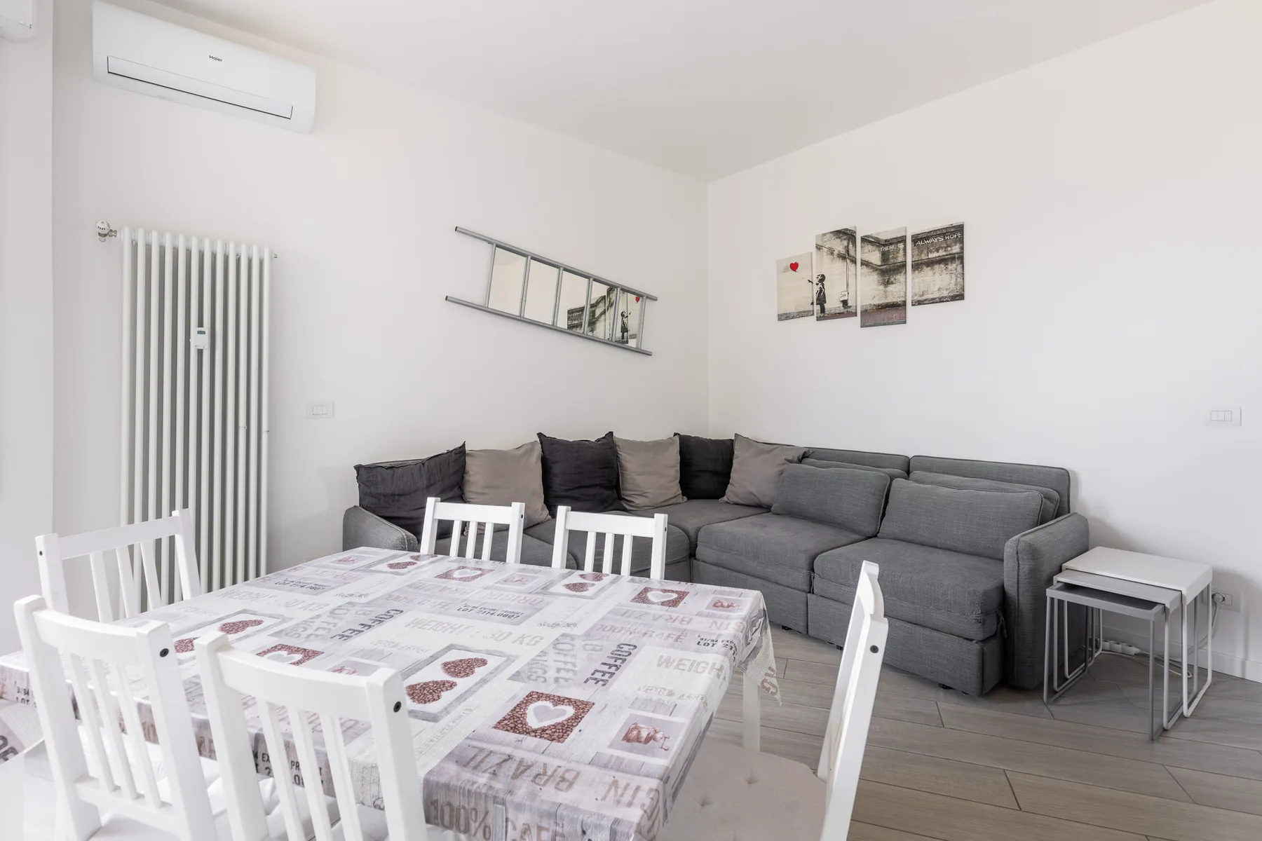 Una sala luminosa con asientos grises y una mesa de comedor.