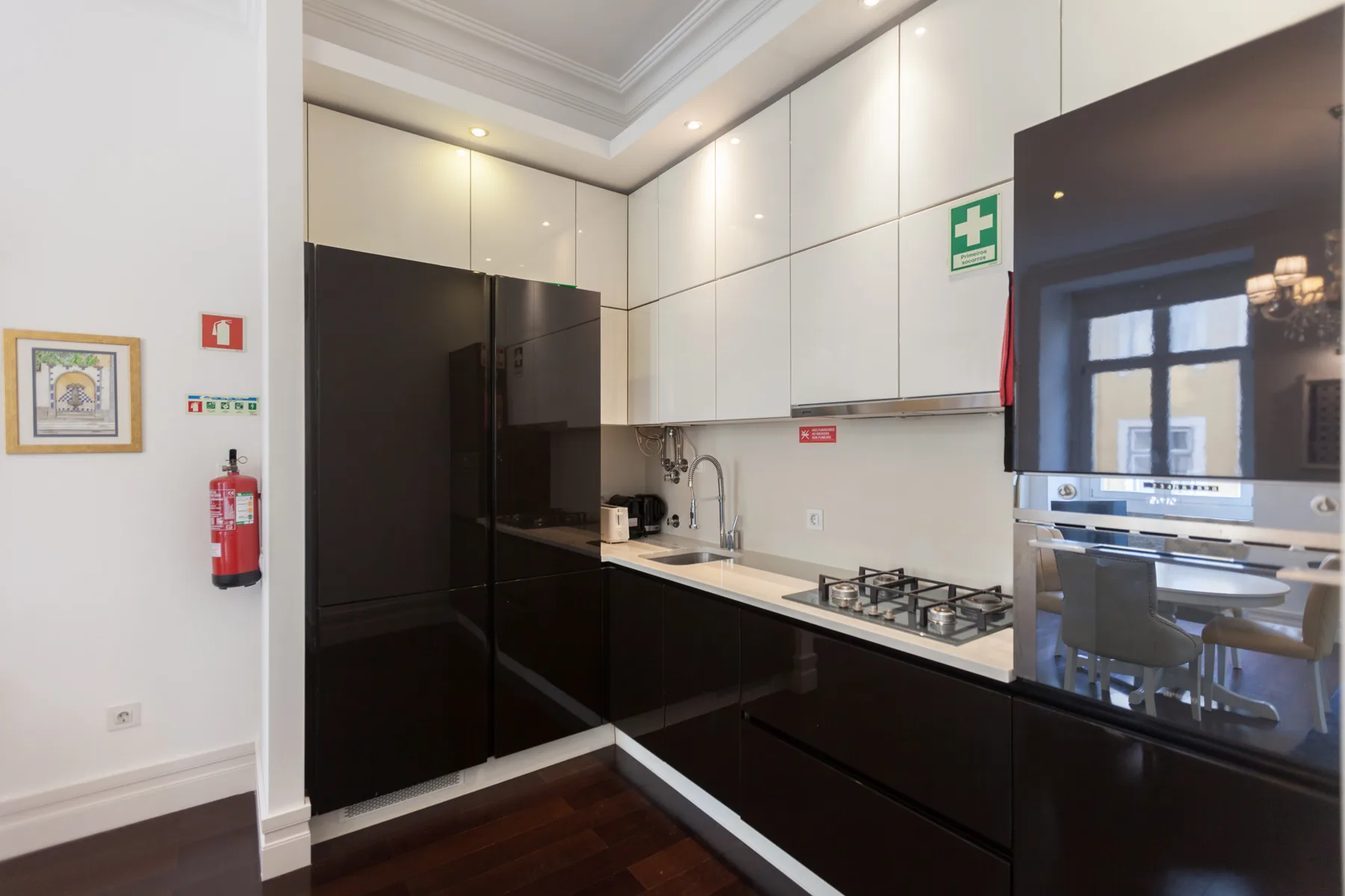 Una cocina moderna con gabinetes oscuros, refrigerador y placa de cocina.