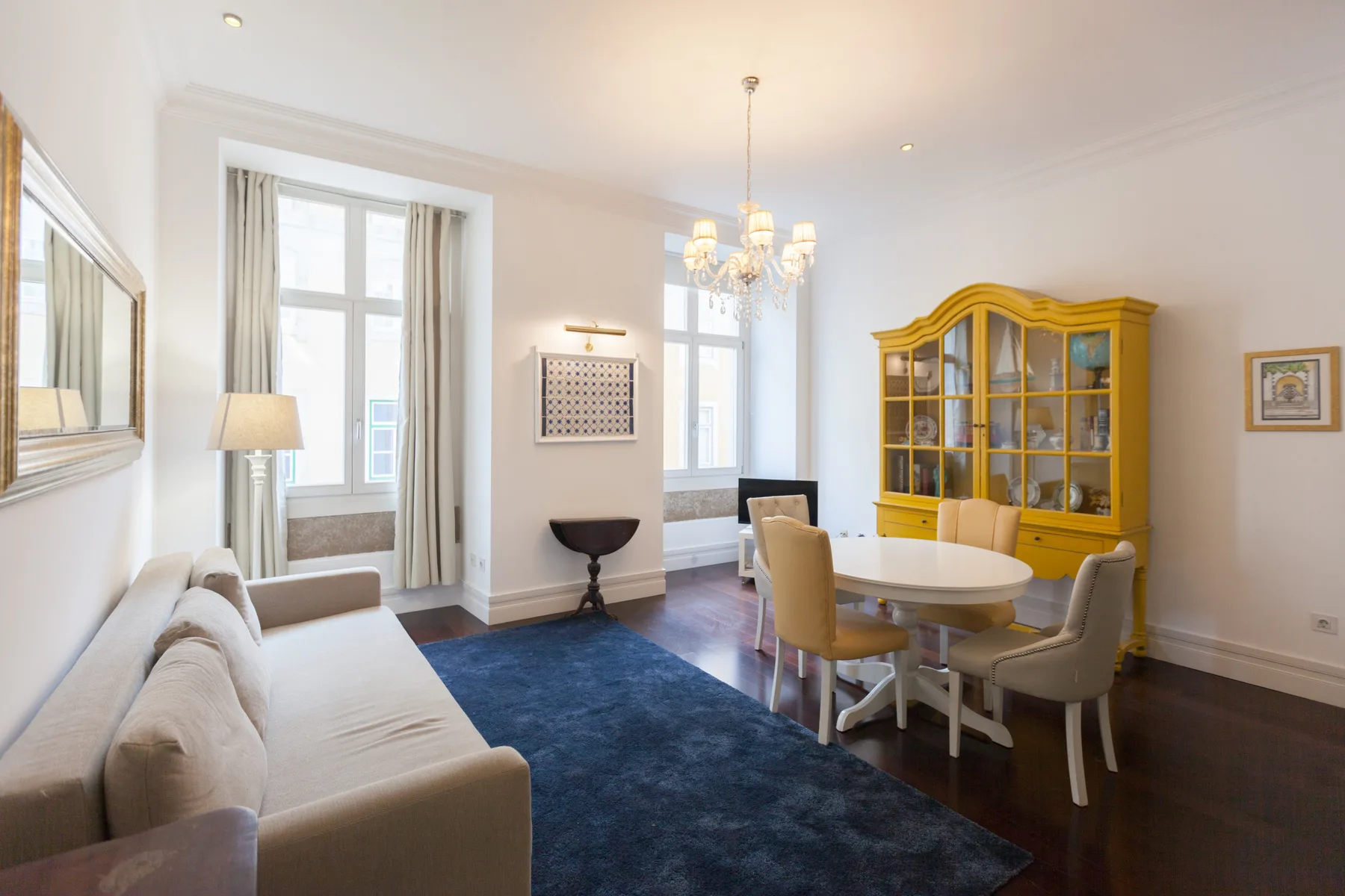 Una luminosa sala de estar y comedor con una zona de asientos y un mueble amarillo.