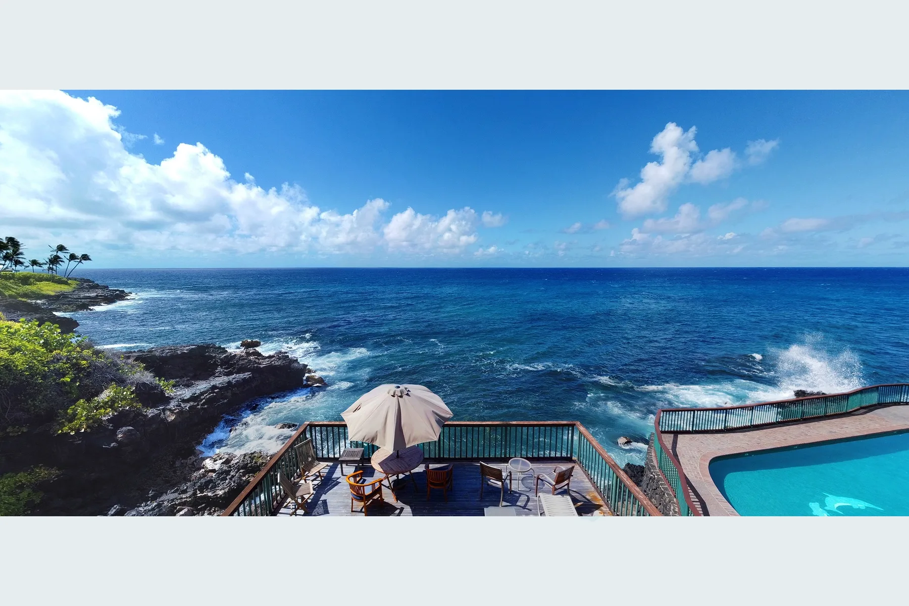 Un patio junto al mar da al océano, con una piscina al lado.