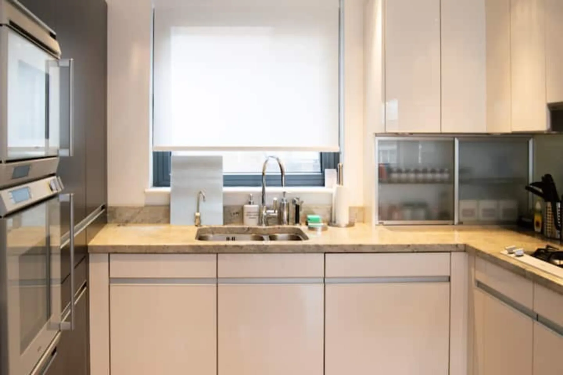 A bright kitchen with a sink and countertop beneath a window.