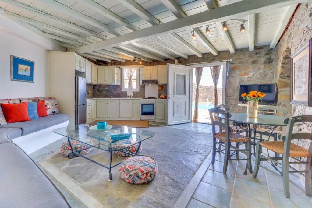 A combined living and dining area with a compact kitchen and glass doors.