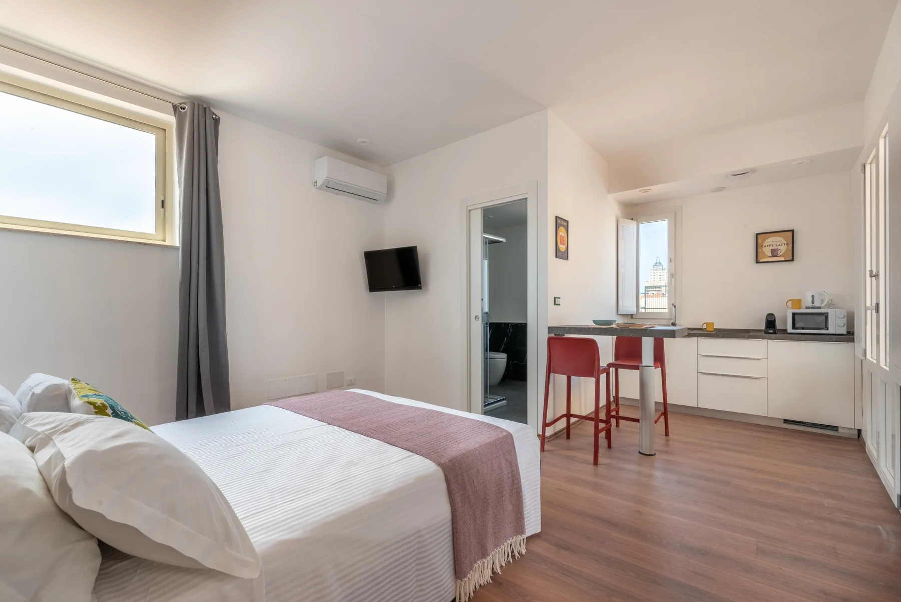 A bedroom opens onto a compact kitchen and dining area.