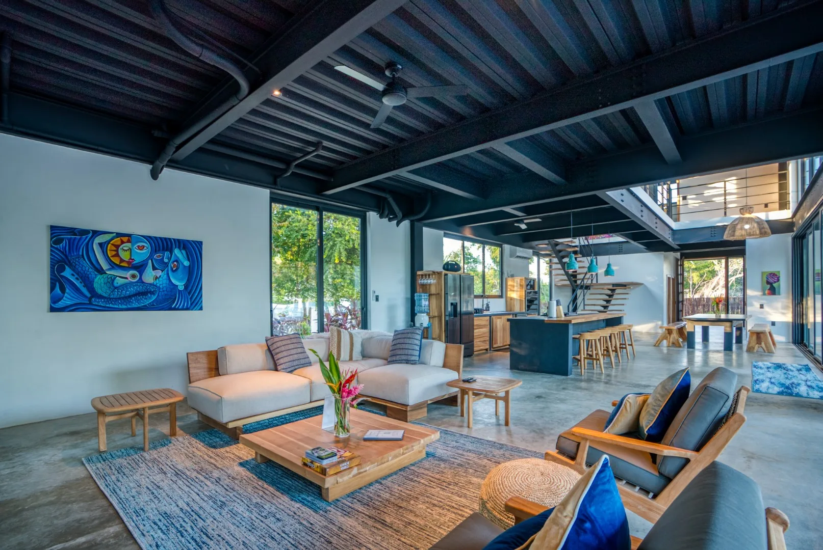 An open-plan living room and kitchen with seating around a low coffee table.