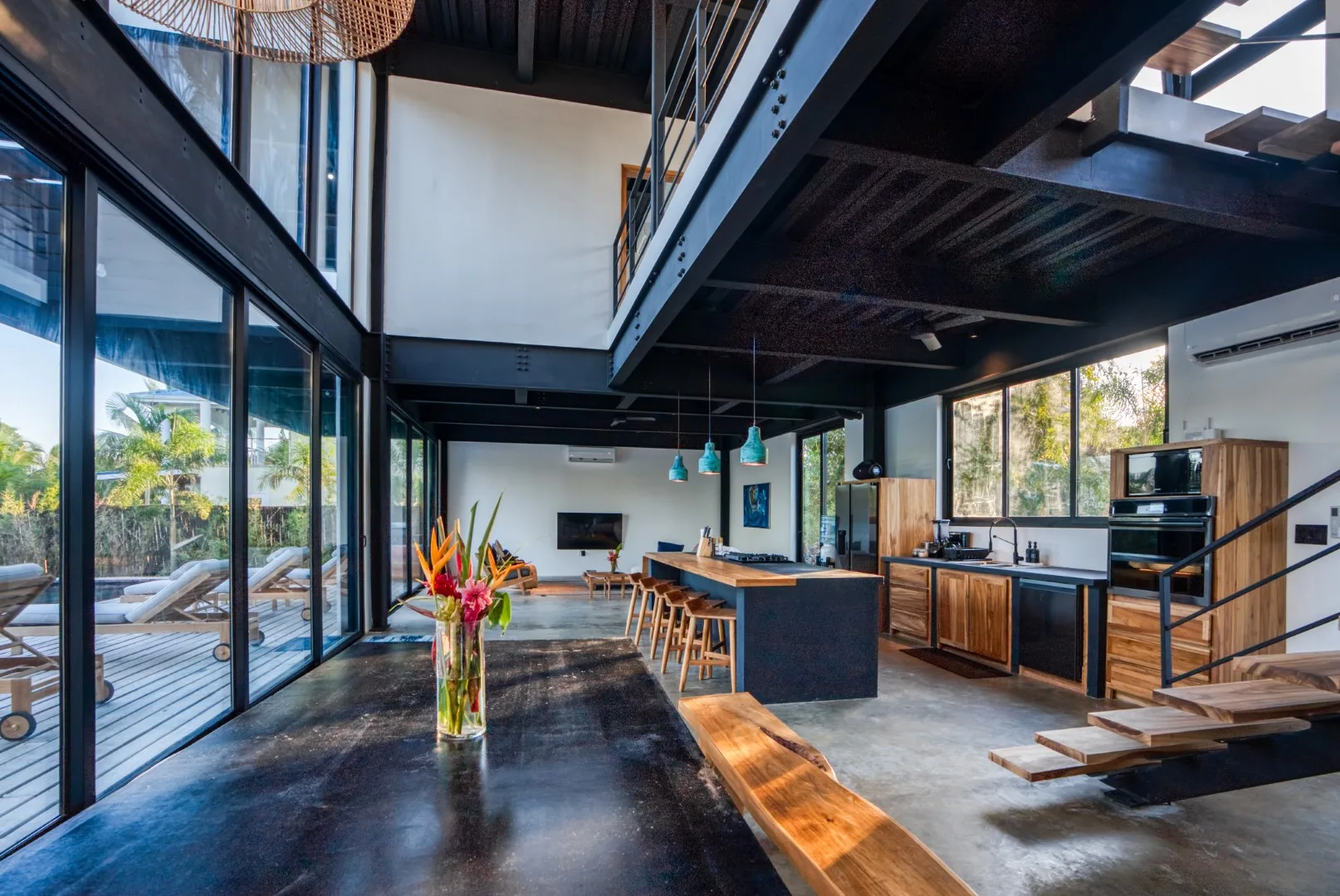 An open-plan kitchen and dining area with large glass doors opening onto a deck.