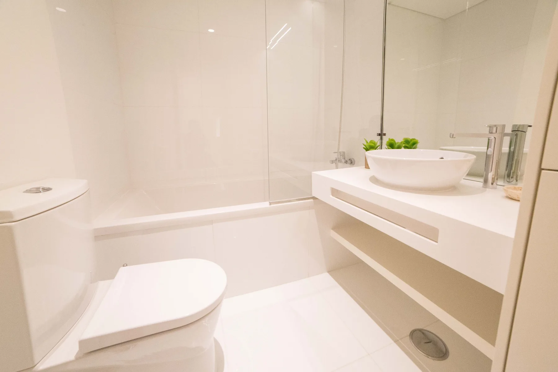 Un baño luminoso con bañera y lavabo sobre un mueble suspendido.