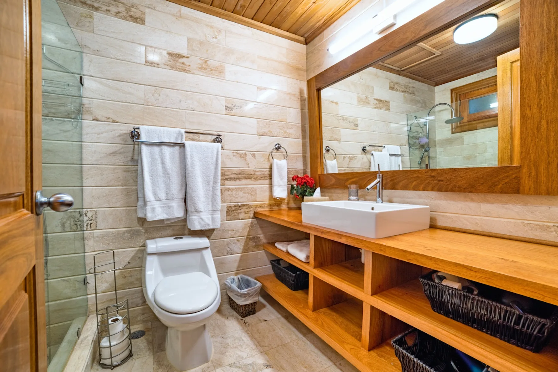 Un baño con inodoro, lavabo y un espejo grande.