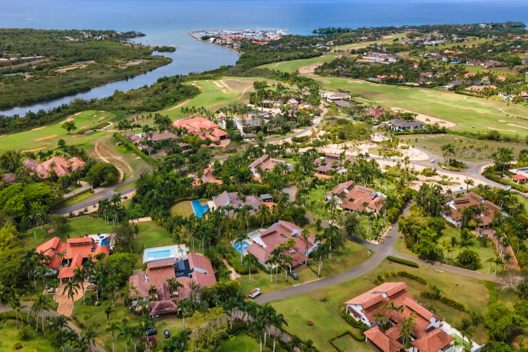 Vista aérea de una zona residencial verde con edificios dispersos y canales de agua.