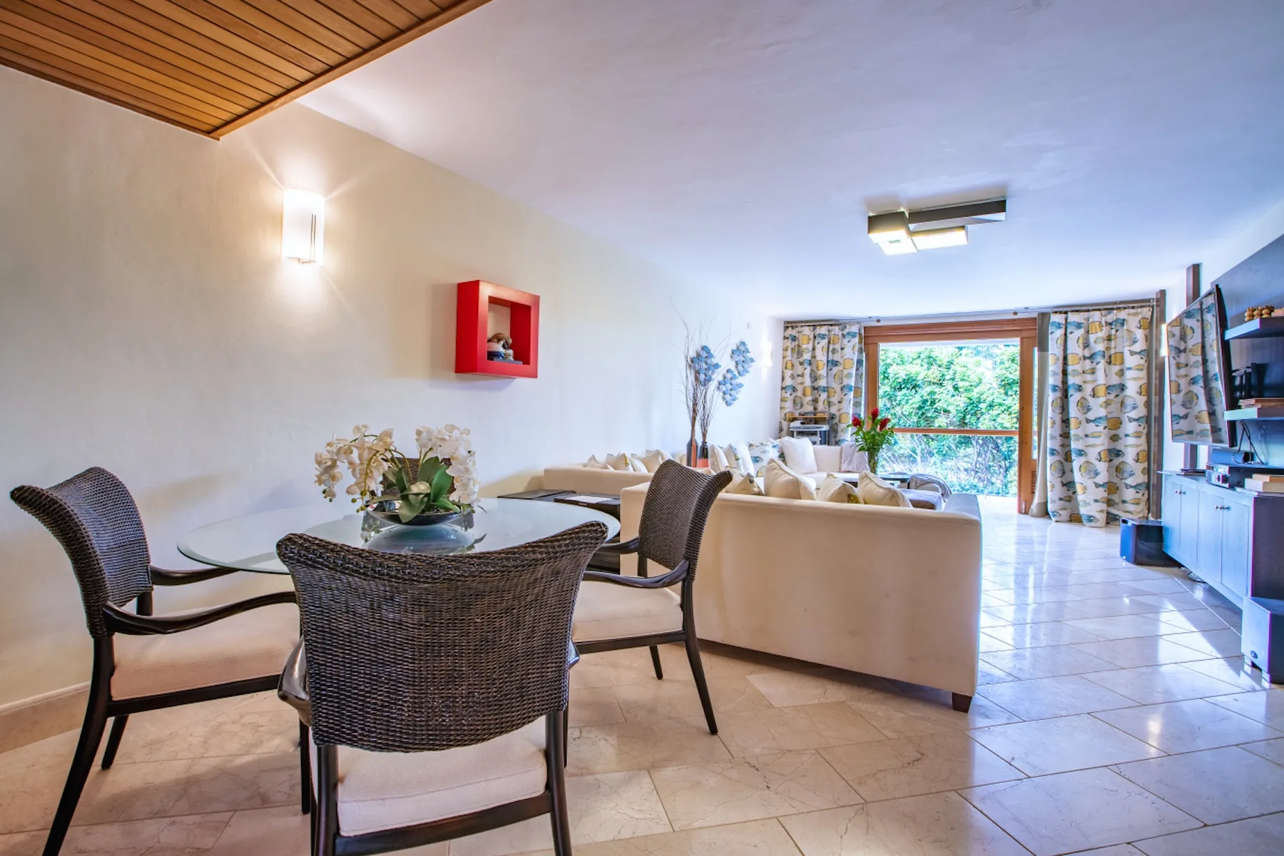 Una zona de estar y comedor con asientos, una mesa y una ventana.
