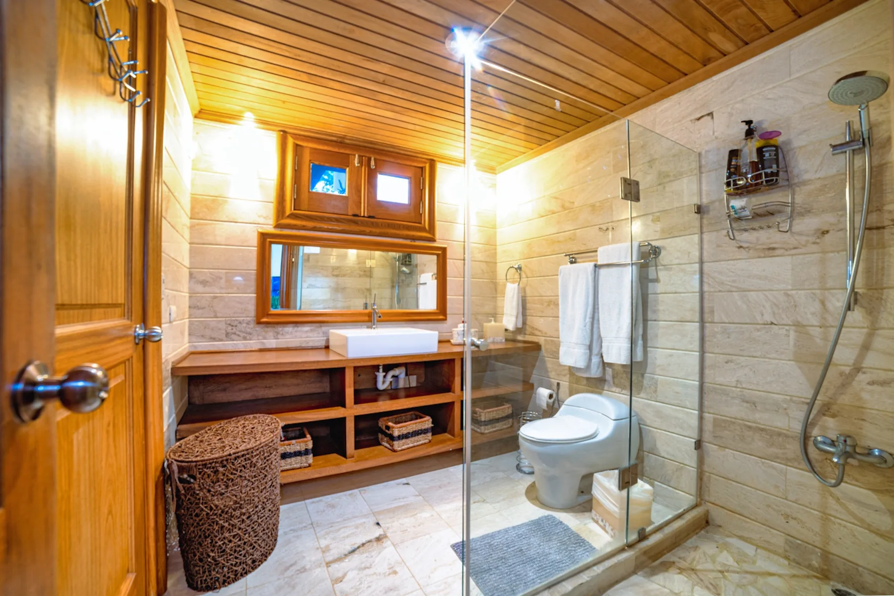 Un baño con lavabo, inodoro y ducha con mampara de vidrio.