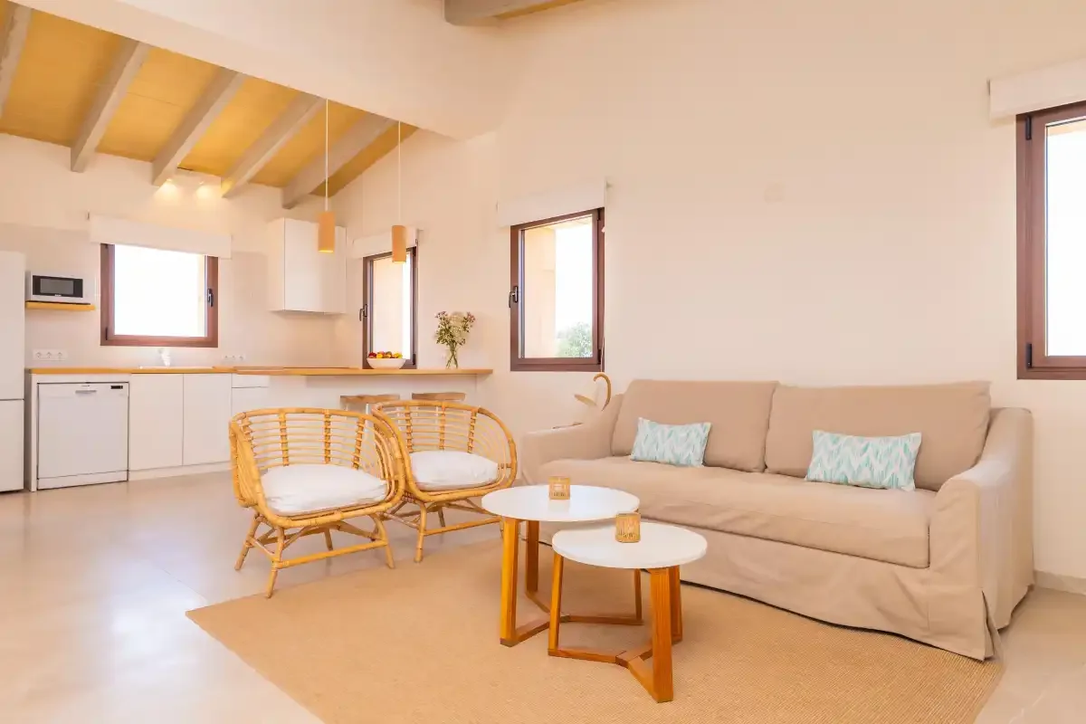 A bright living area with seating and an open kitchen.
