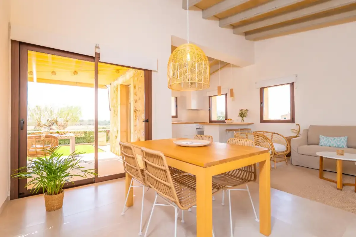 A dining area with a wooden table and sliding glass doors opening to a patio.
