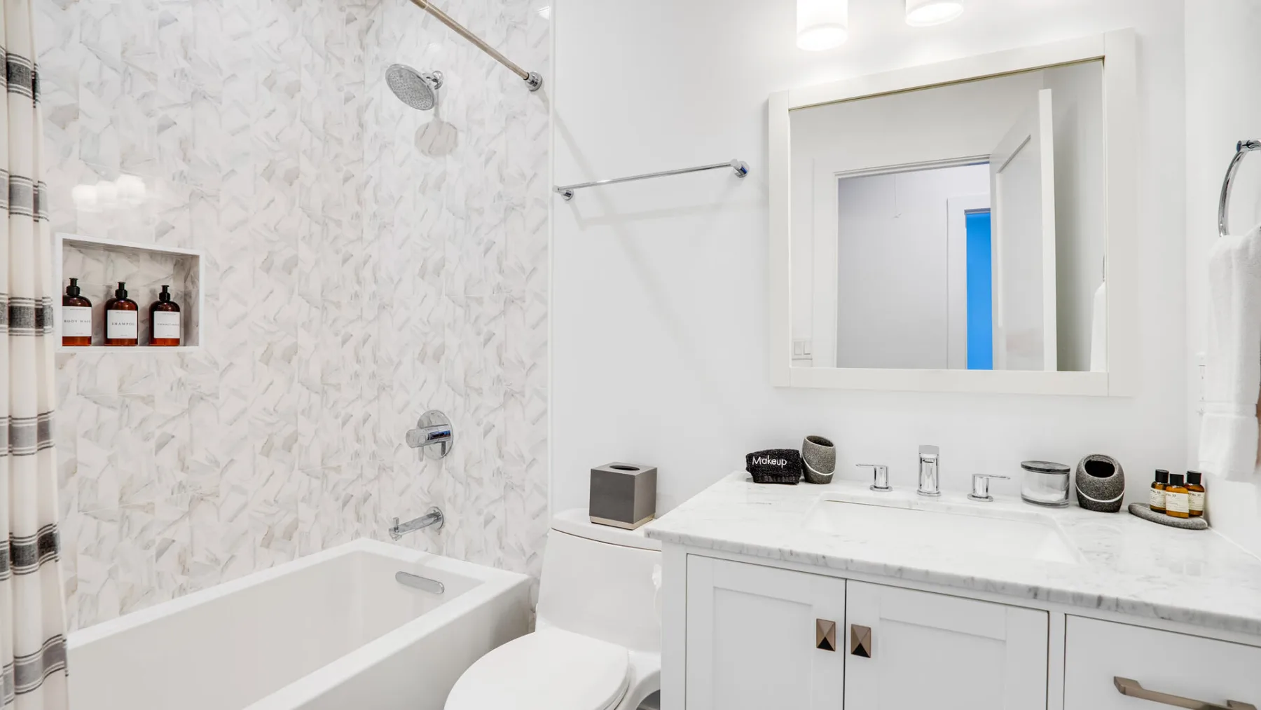 A bright bathroom with a bathtub, shower, and white vanity.