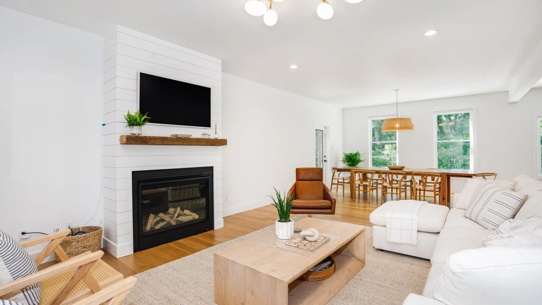 A bright living room with a fireplace, seating, and a dining table.
