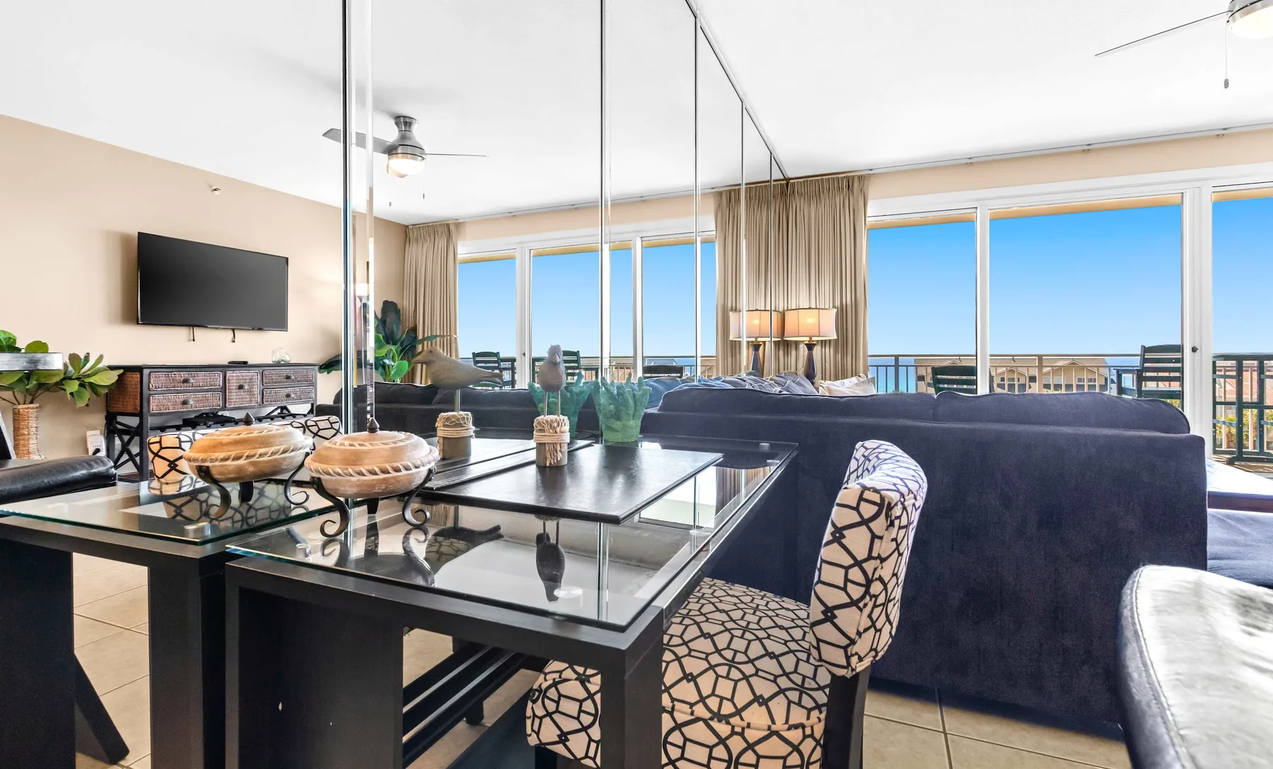 A bright living and dining area with large windows overlooking the ocean.