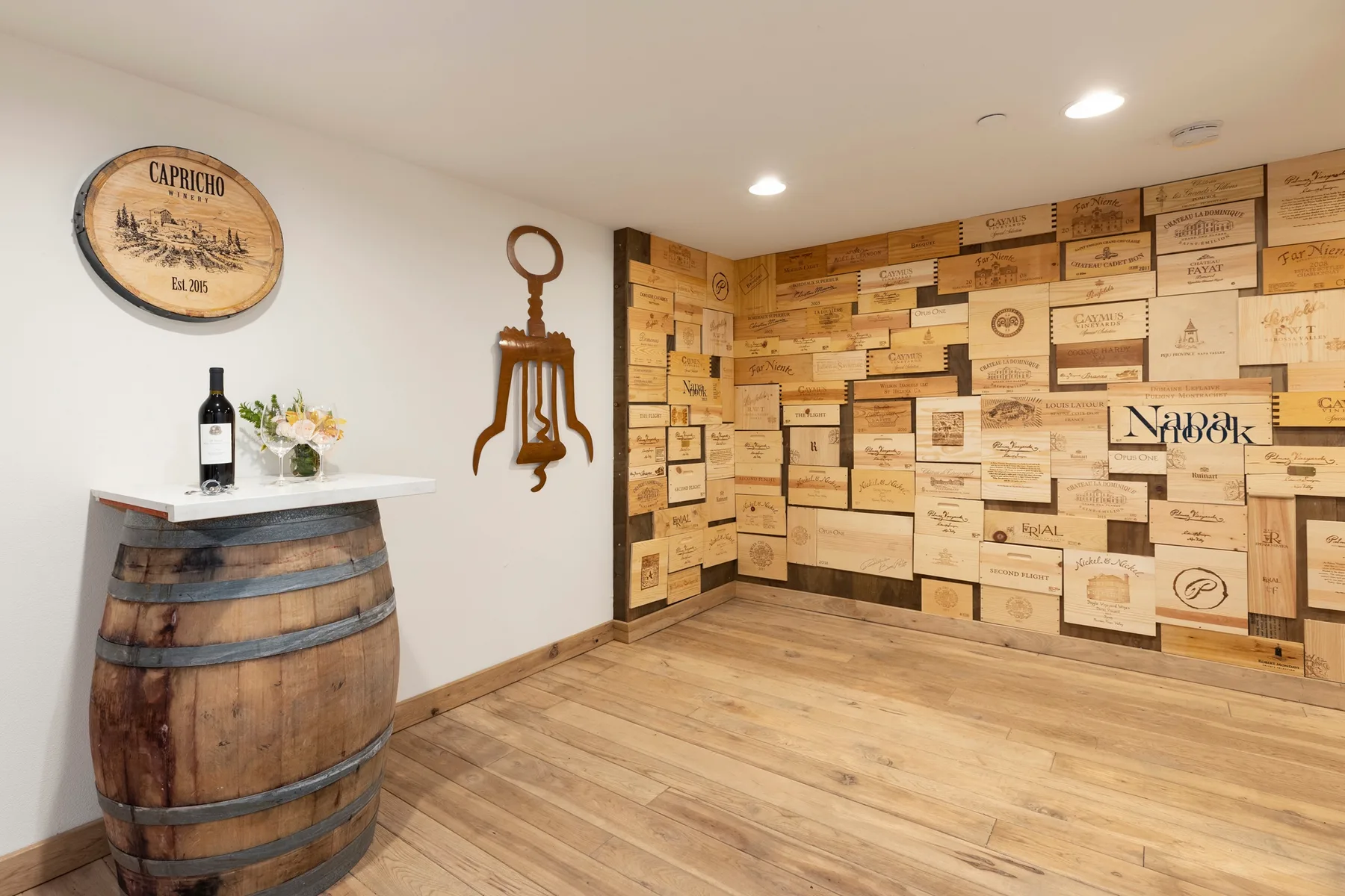 Una sala temática de vino con suelo de madera y paredes decoradas con cajas de vino.